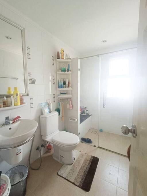 Bright white tiled bathroom with shower cabin