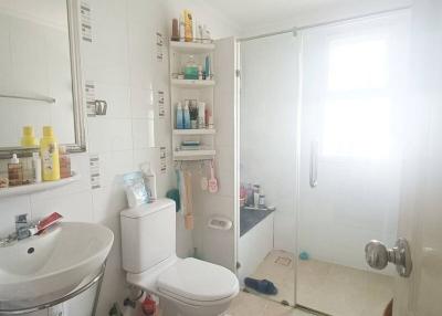 Bright white tiled bathroom with shower cabin