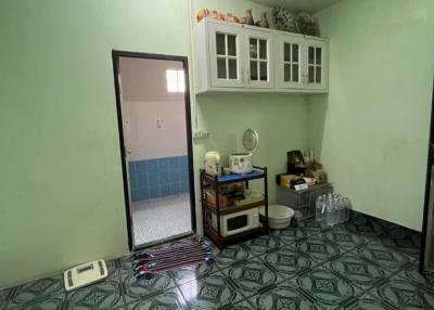 Compact kitchen area with green walls and patterned floor.