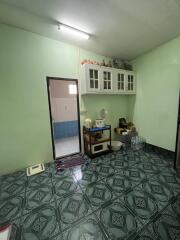 Compact kitchen area with green walls and patterned floor.