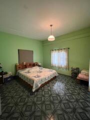 Spacious bedroom with queen-sized bed and patterned tile flooring