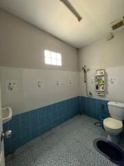 Bright bathroom with a small window, tiled floors, and essential fixtures