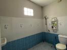 Bright bathroom with a small window, tiled floors, and essential fixtures