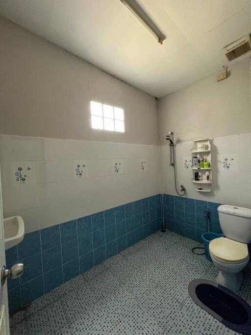 Bright bathroom with a small window, tiled floors, and essential fixtures