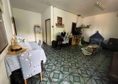 Spacious living room with patterned tile flooring and various personal items