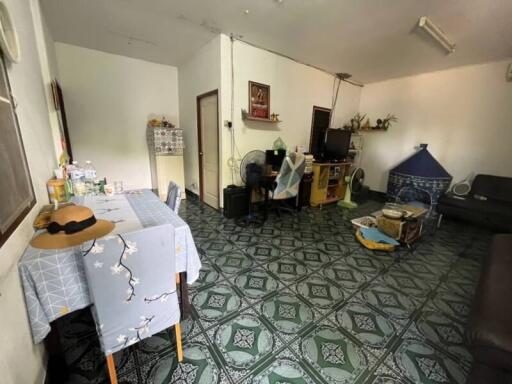 Spacious living room with patterned tile flooring and various personal items