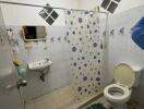 Compact bathroom with shower curtain and tiled walls