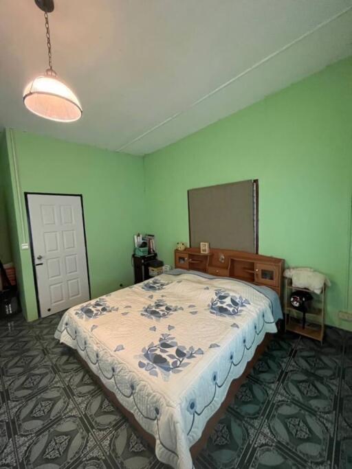 Spacious bedroom with green walls and patterned floor tile
