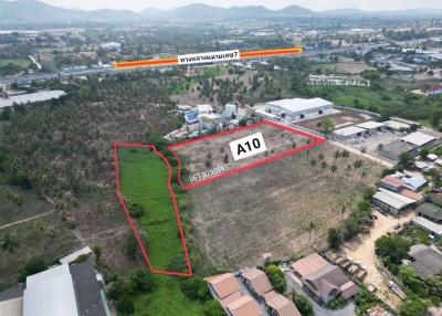 Aerial view of a vacant land plot outlined in red with surrounding urban area