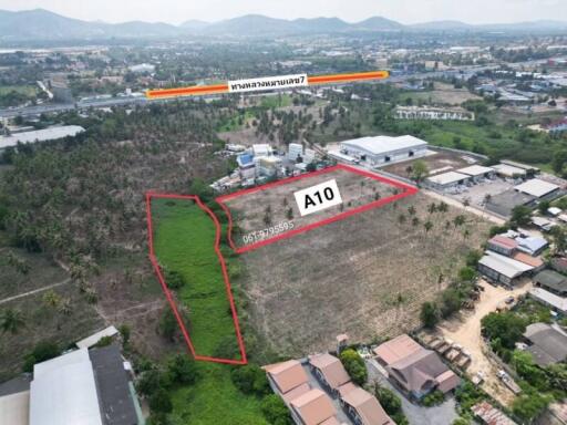 Aerial view of a vacant land plot outlined in red with surrounding urban area