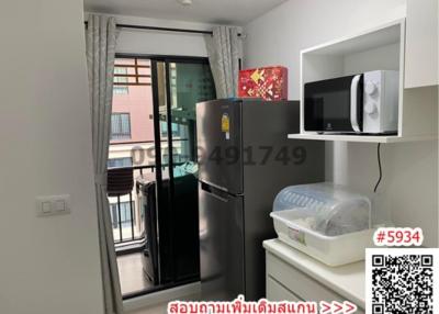 Compact kitchen with appliances and balcony access