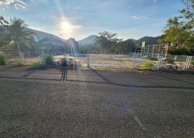 Sunlit paving with fencing and mountain in the background