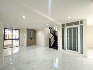 Spacious and well-lit living area with shiny marble flooring