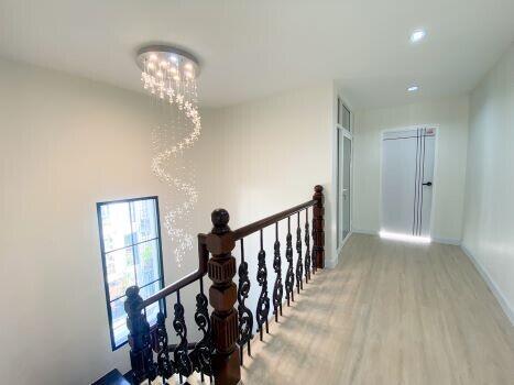 Bright upstairs hallway with wooden flooring and wrought-iron railing