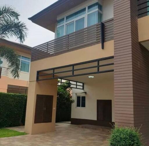 Modern two-story house with a balcony and carport