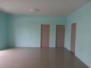 Spacious empty bedroom with blue walls and laminate flooring