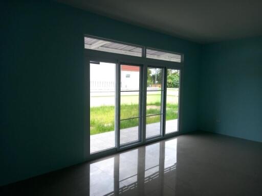 Spacious and well-lit living room with large sliding glass doors leading to exterior