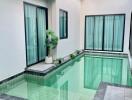 Indoor swimming pool with large windows and natural lighting