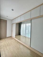 Spacious bedroom with large mirrored wardrobe and wooden flooring