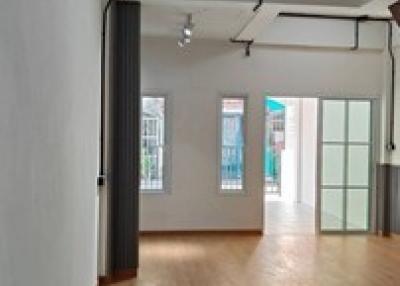 Interior view of a spacious room with hardwood flooring and natural light