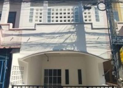 Two-story residential building exterior with gated entrance