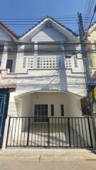 Two-story residential building exterior with gated entrance