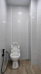 Compact bathroom with glossy white tiles and modern toilet