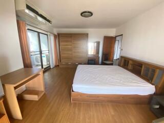 Spacious bedroom with wooden furniture and balcony access