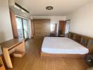 Spacious bedroom with wooden furniture and balcony access