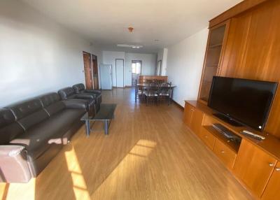 Spacious living room with hardwood floors, modern furniture, and abundant natural light
