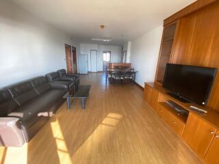 Spacious living room with hardwood floors, modern furniture, and abundant natural light