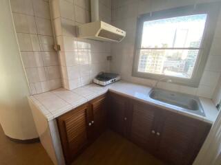 Compact kitchen with window and tiled walls