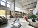 Spacious and elegant lobby area with a grand staircase and high ceiling