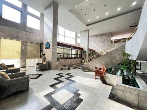 Spacious and elegant lobby area with a grand staircase and high ceiling