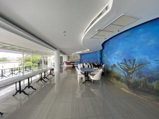 Spacious communal dining or meeting area in a modern building with artistic wall mural