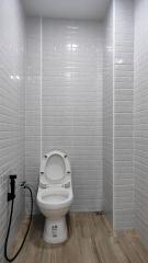 Modern bathroom with white tiles and wall-mounted toilet