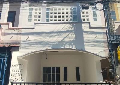 Two-story residential home with a white facade and gated entrance