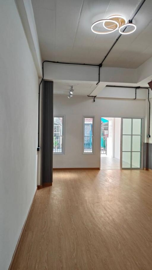 Spacious living room with hardwood floors and natural light