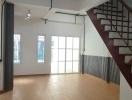 Spacious living area with large windows and modern staircase