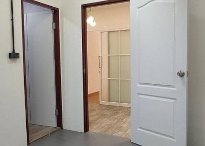 Interior view of a room with tiled flooring, white doors, and a skylight