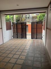 View of the house entrance showing the gate and a tiled pathway