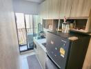 Modern kitchen with balcony access equipped with stainless steel appliances and ample cabinet space