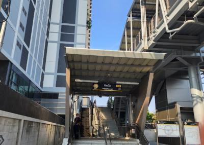 Entrance of a modern high-rise building with stairs and a covered walkway