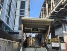 Entrance of a modern high-rise building with stairs and a covered walkway