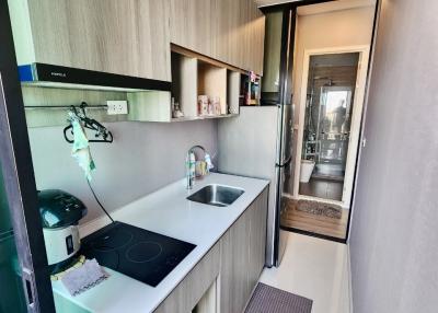Compact modern kitchen with built-in appliances and wooden cabinets