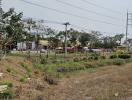 Empty land available for development with sparse vegetation and utility poles