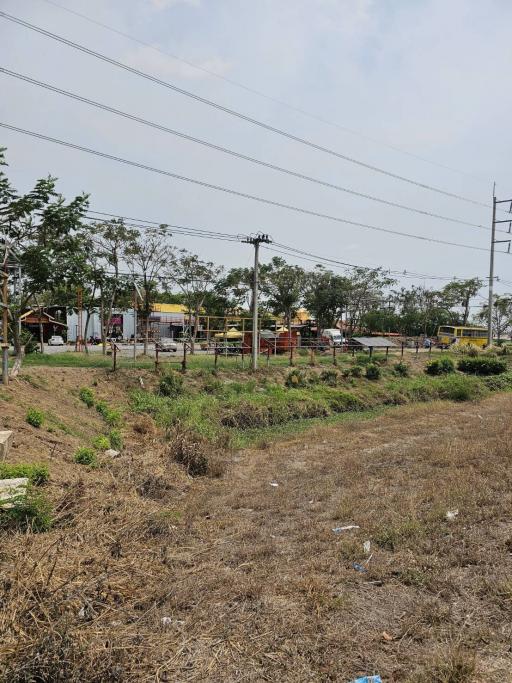 Empty land available for development with sparse vegetation and utility poles