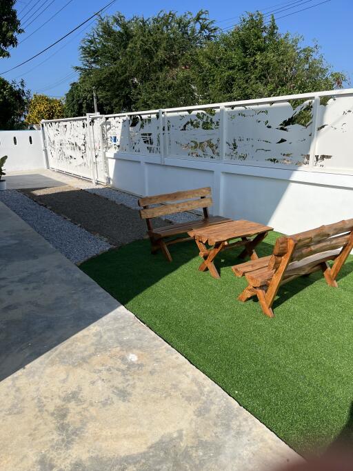 Outdoor seating area with artificial grass and wooden benches