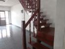 Wooden staircase in a home interior with tile flooring