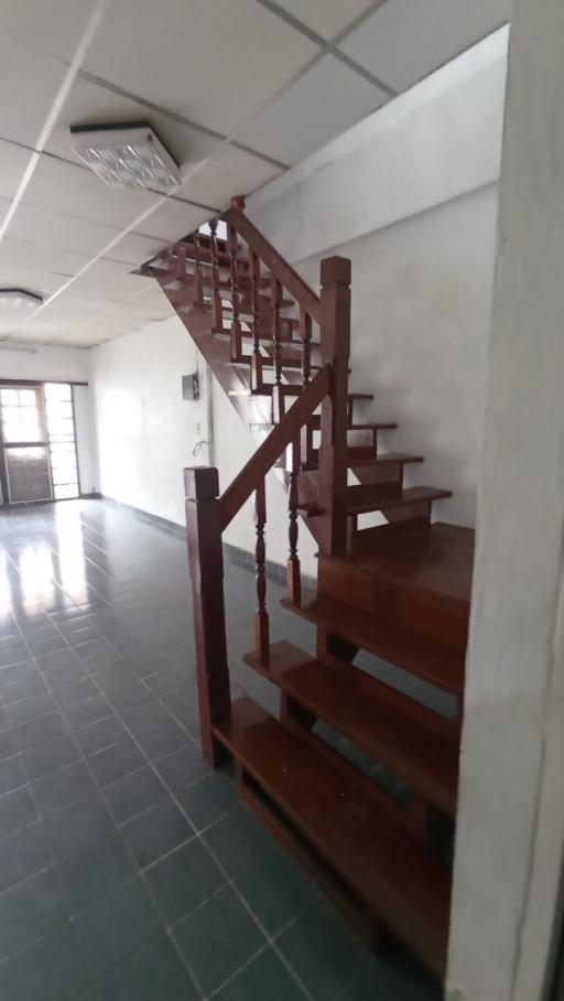 Wooden staircase in a home interior with tile flooring